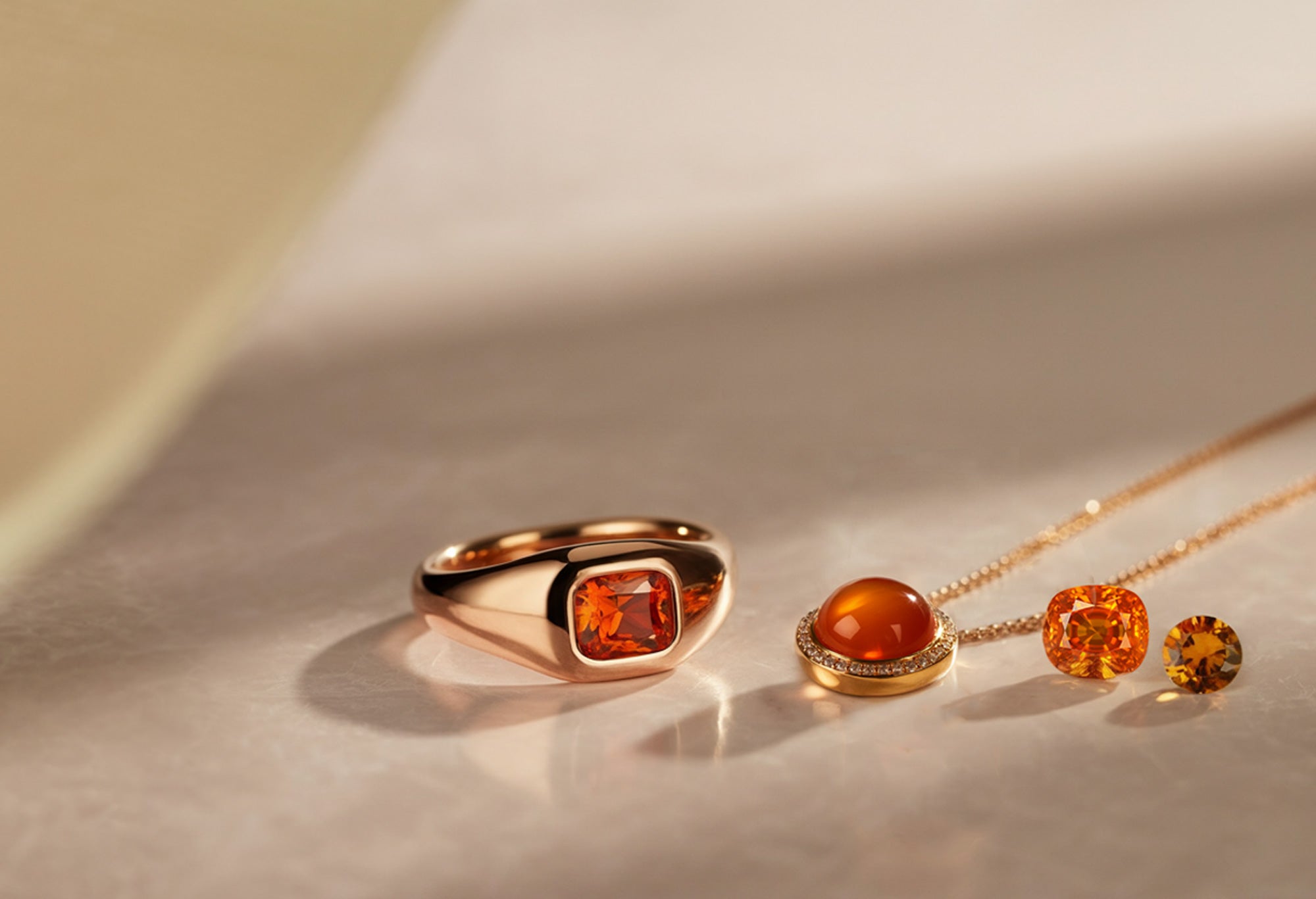 Bijoux en or rose avec spessartite et cornaline, illustrant l’élégance des pierres précieuses orange.