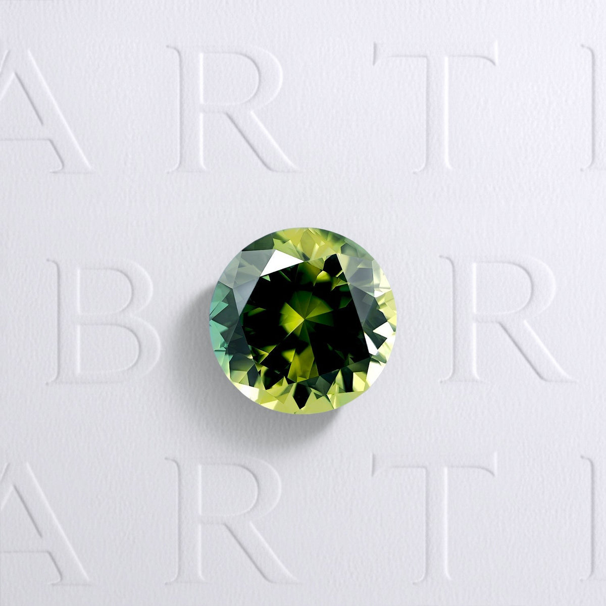 Saphir bicolore naturel rond facetté de 1.53 carat, originaire d’Australie, présentant des couleurs bleu-vert et jaune, sans inclusion visible à l’œil nu et non traité.