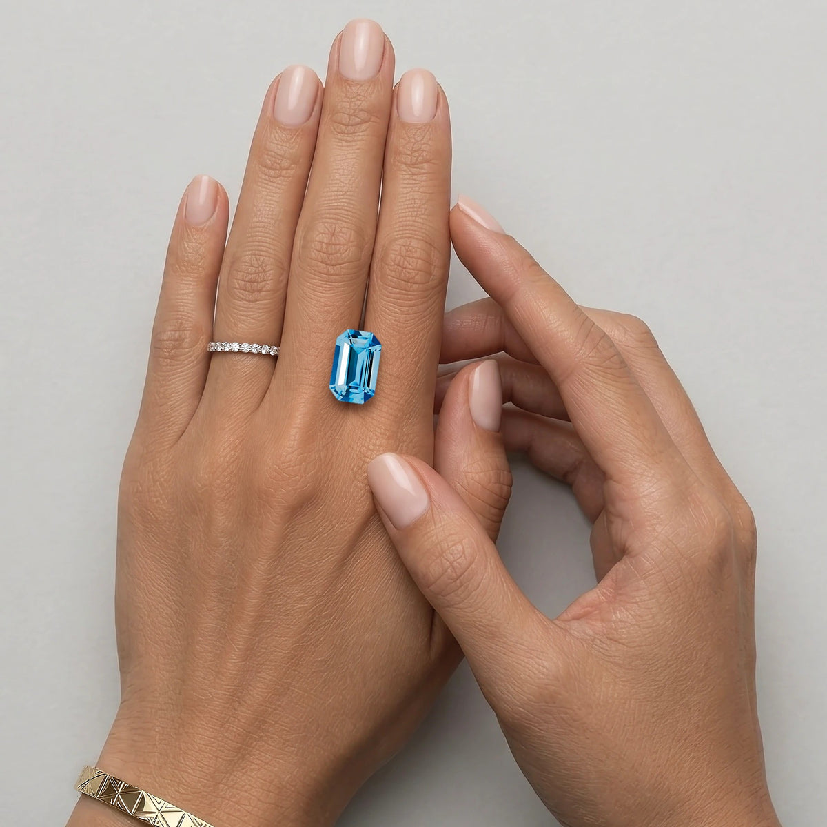 Topaze bleue non sertie de 6,96 carats mesurant 14,1 sur 9 mm, présentée sur une main à taille réelle