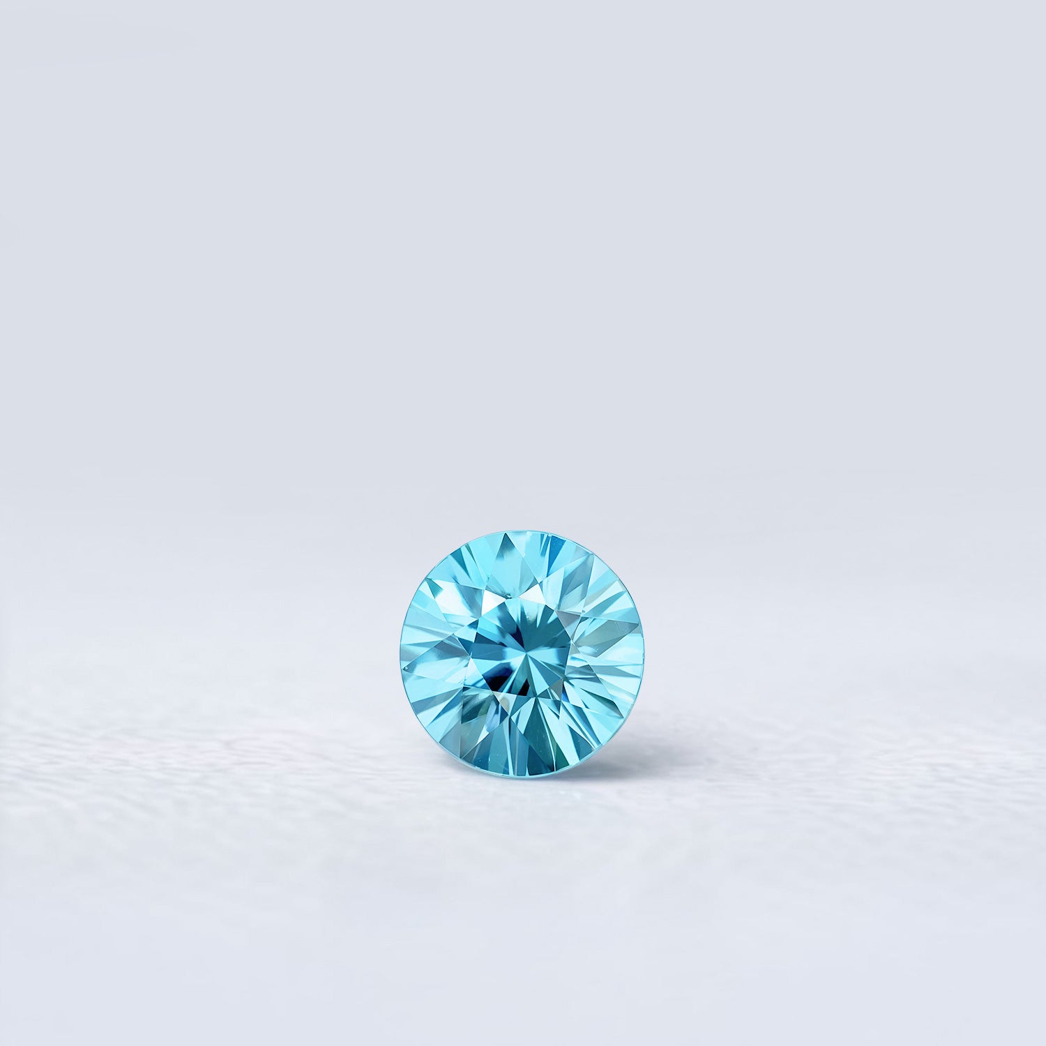 Zircon bleu naturel rond de 1.46 carat facetté, couleur cyan prononcé, origine Cambodge