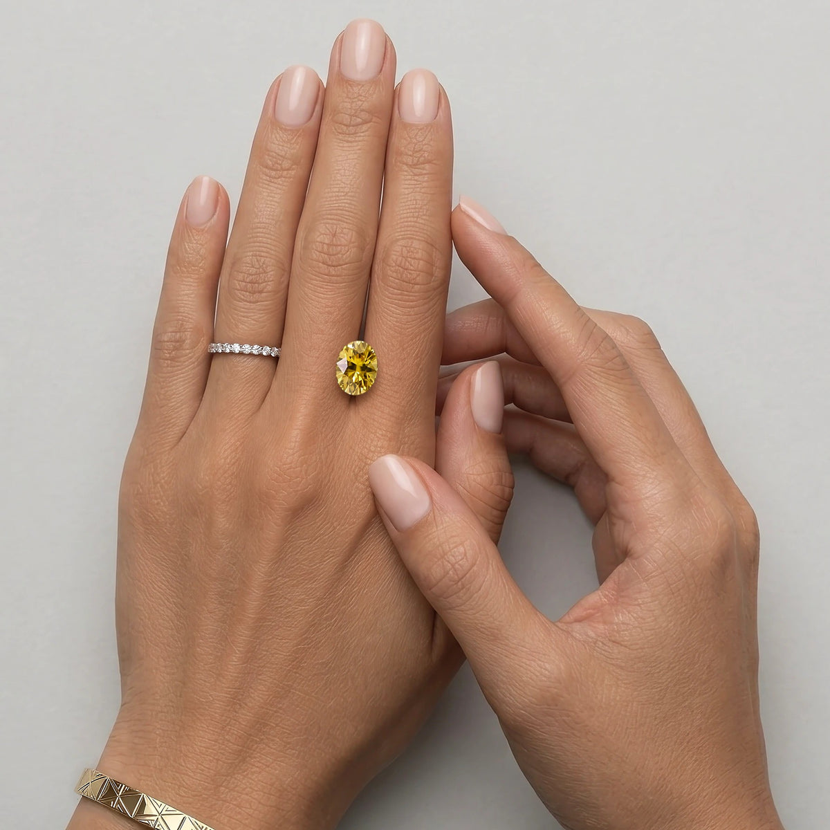 Zircon jaune non serti de 4,45 carats mesurant 10,6 sur 8,1 mm, présenté sur une main à taille réelle