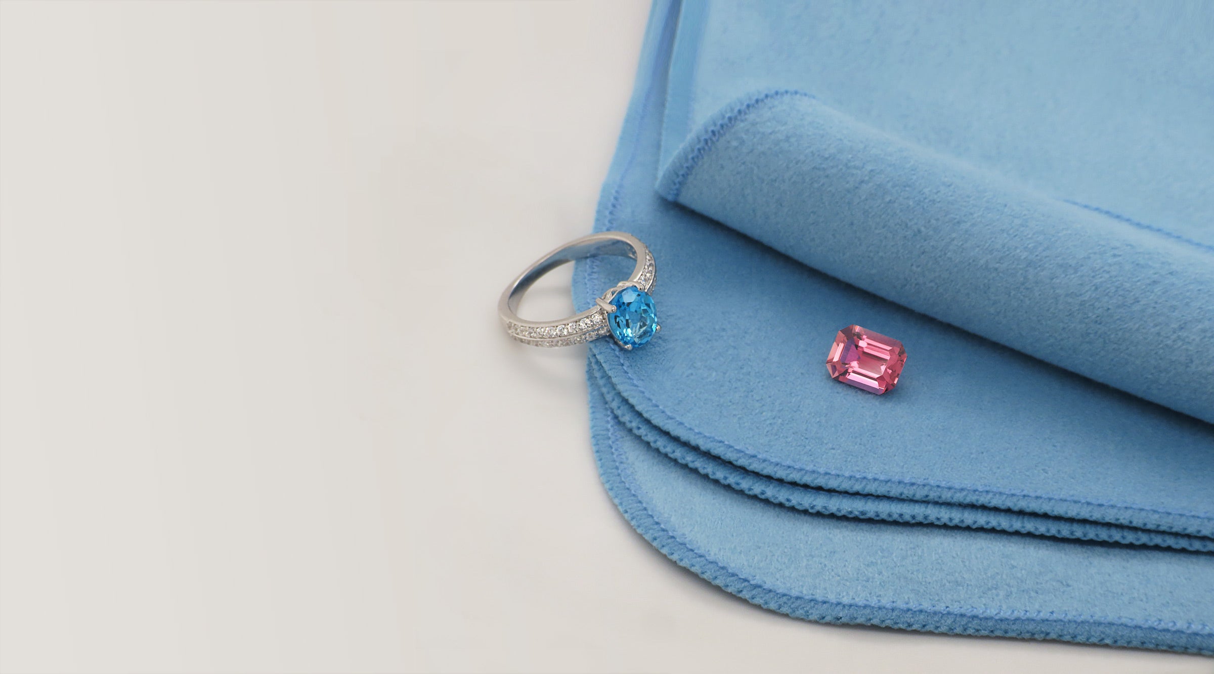 Conseils d'entretien des gemmes, Bijou et pierre fine posés sur un tissu de nettoyage, pour préserver leur éclat et leur beauté durable.