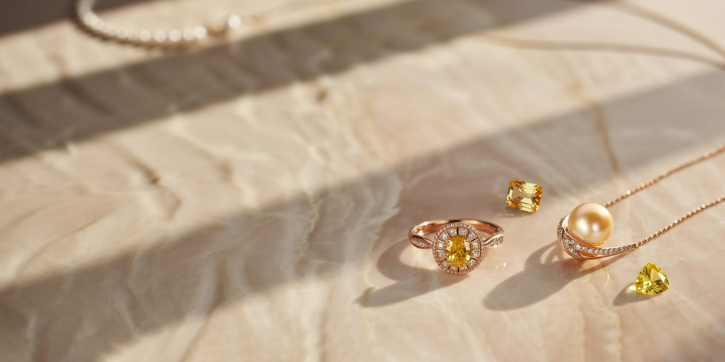 Pierres précieuses jaunes mises en valeur dans des bijoux en or jaune sur fond texturé.