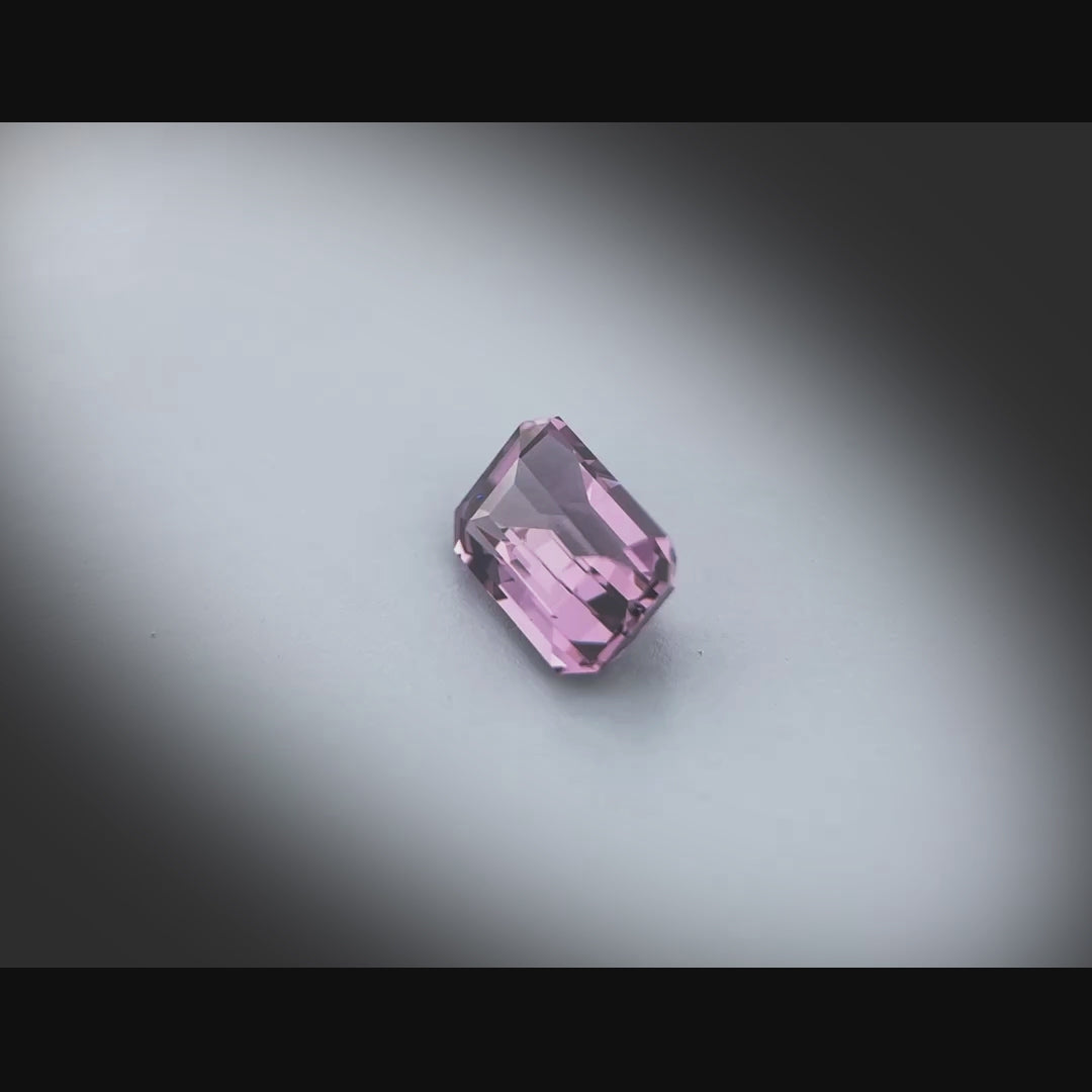 Vidéo d’un spinelle naturel violet rectangulaire à pans coupés de 1.51 ct, facetté et sans inclusion visible, originaire du Sri Lanka, tournant à 360 degrés sur fond gris clair