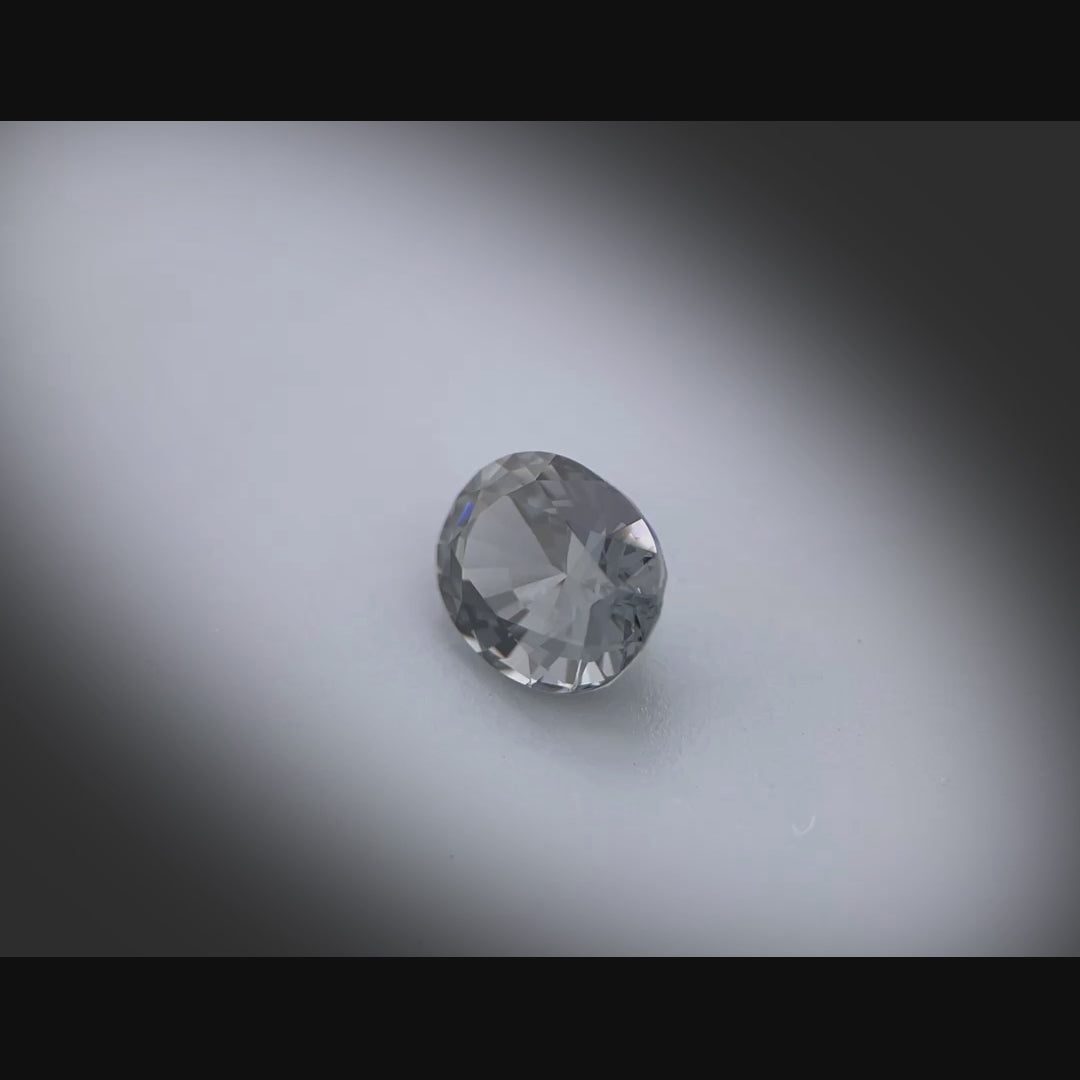 Vidéo d’un spinelle naturel gris ovale de 1.64 ct, facetté, originaire du Myanmar, sans inclusion visible à la loupe 10x, tournant à 360 degrés sur fond gris clair