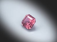 Vidéo d’une tourmaline rose naturelle carrée à pans coupés facettée de 2.31 ct, originaire du Congo, de couleur rose soutenu, tournant sur un fond gris clair.
