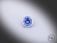 Vidéo d’un saphir bleu rond facetté de 0.57 ct, originaire du Sri Lanka, de couleur bleu prononcé, chauffe classique, pierre précieuse tournant sur un fond gris clair.