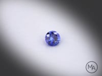 Vidéo d’un saphir bleu naturel rond facetté de 0.19 ct, originaire du Sri Lanka, de couleur bleu soutenu, pierre tournant sur un fond gris clair.