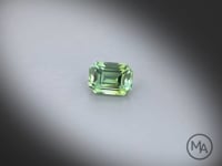 Vidéo d’une tourmaline verte naturelle rectangle à pans coupés facettée de 1.34 ct, de couleur vert prononcé, tournant à 360 degrés sur un fond gris clair.