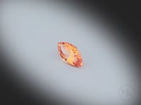 Vidéo d’un grenat spessartite naturel navette facetté de 0.91 ct, originaire du Nigéria, de couleur orange prononcé, rotation sur un fond gris clair.