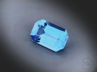 Vidéo d’une topaze bleue taille RPC de 6.96 ct, originaire du Brésil, de couleur cyan bleuté intense, tournant sur un fond gris clair.