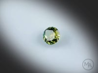 Vidéo d’un saphir bicolore naturel rond facetté de 1.53 ct, originaire d’Australie, présentant une association naturelle de bleu-vert et de jaune, rotation sur un fond gris clair.