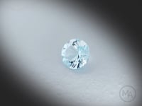 Vidéo d’une topaze bleue naturelle Sky Blue ronde facettée de 1.67 ct, originaire du Brésil, de couleur cyan-bleuté très léger, pierre tournant degrés sur un fond gris clair.