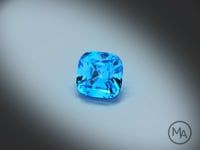 Vidéo d’une topaze bleue naturelle Swiss Blue coussin carré facettée de 4.10 ct, originaire du Brésil, de couleur cyan-bleuté intense, rotation sur un fond gris clair.