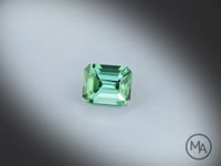 Vidéo d’une Tourmaline verte naturelle rectangle à pans coupés facettée de 2.23 ct, originaire de RD Congo, de couleur vert-bleuté soutenu, pierre fine tournant sur un fond gris clair.