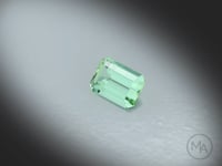 Vidéo d’une Tourmaline verte naturelle rectangle à pans coupés facettée de 2.16 ct, originaire d’Afghanistan, de couleur vert-bleuté prononcé, pierre fine tournant sur un fond gris clair.