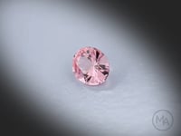 Vidéo d’un Grenat Malaya naturel ovale facetté de 1.78 ct, originaire de Tanzanie, de couleur rose-brun léger, pierre fine atypique tournant sur un fond gris clair.