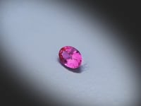 Vidéo d’un Saphir Rose naturel ovale facetté de 0.41 ct, originaire de Madagascar, de couleur rose intense, pierre précieuse tournant sur un fond gris clair.