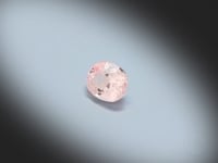 Vidéo d’un Saphir pêche naturel ovale facetté de 1.39 ct, originaire du Sri Lanka, de couleur pêche pastel, pierre précieuse tournant sur un fond gris clair.