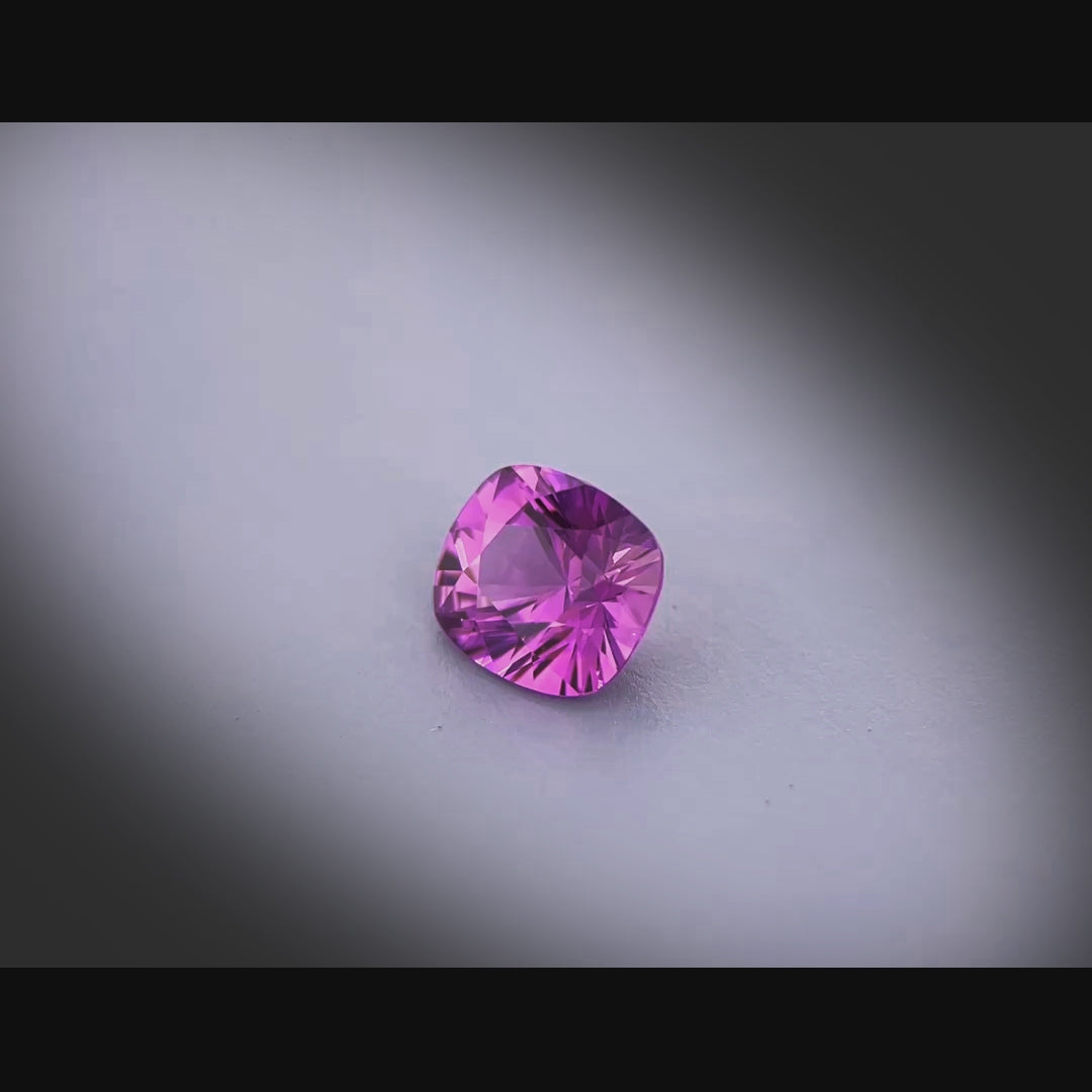 Vidéo d’un saphir violet-rosé naturel coussin facetté de 1.22 ct, originaire du Sri Lanka, de couleur intense, tournant à 360 degrés sur fond gris clair