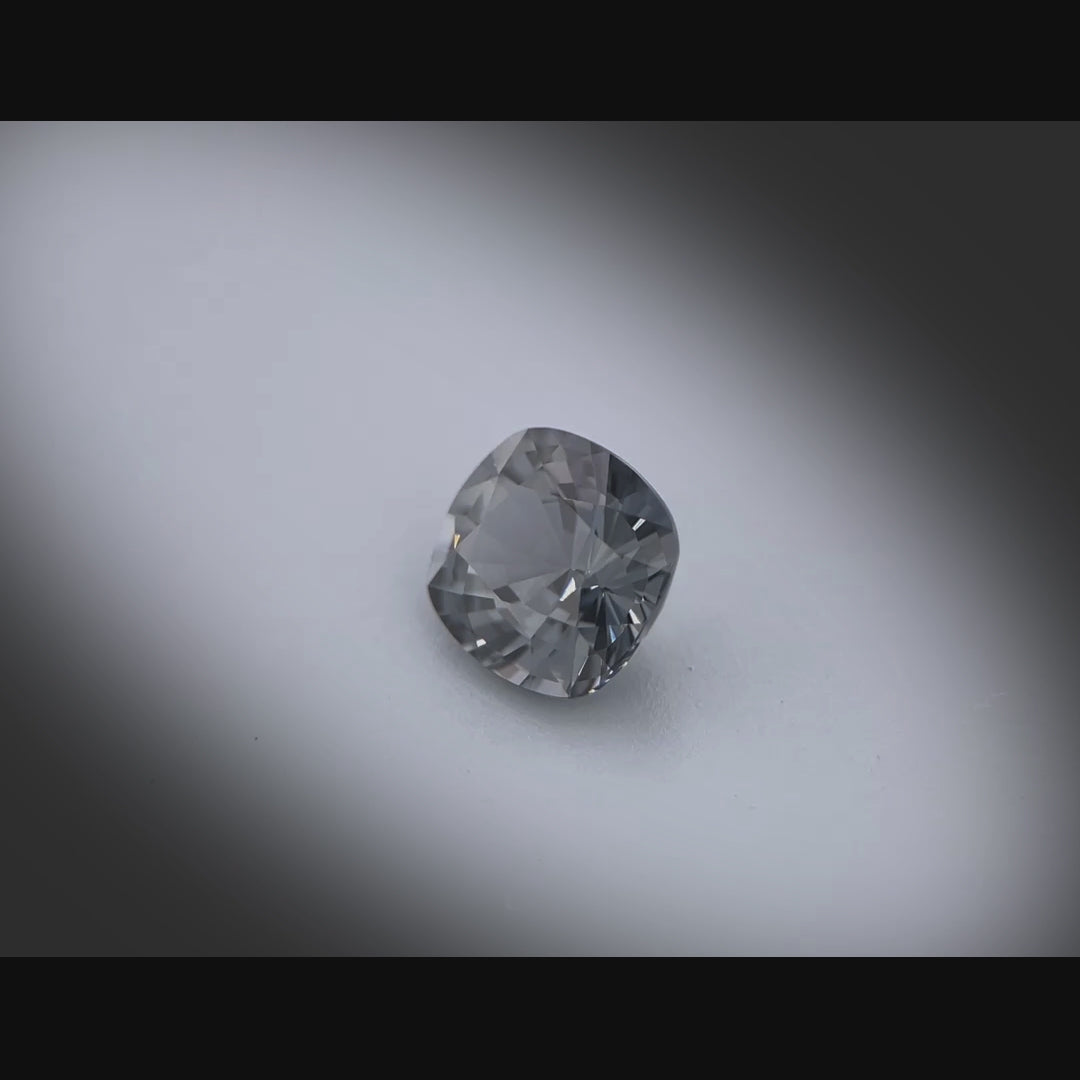 Vidéo d’un spinelle naturel gris coussin rectangulaire de 1.78 ct, facetté et sans inclusion visible, originaire du Myanmar, tournant à 360 degrés sur fond gris clair