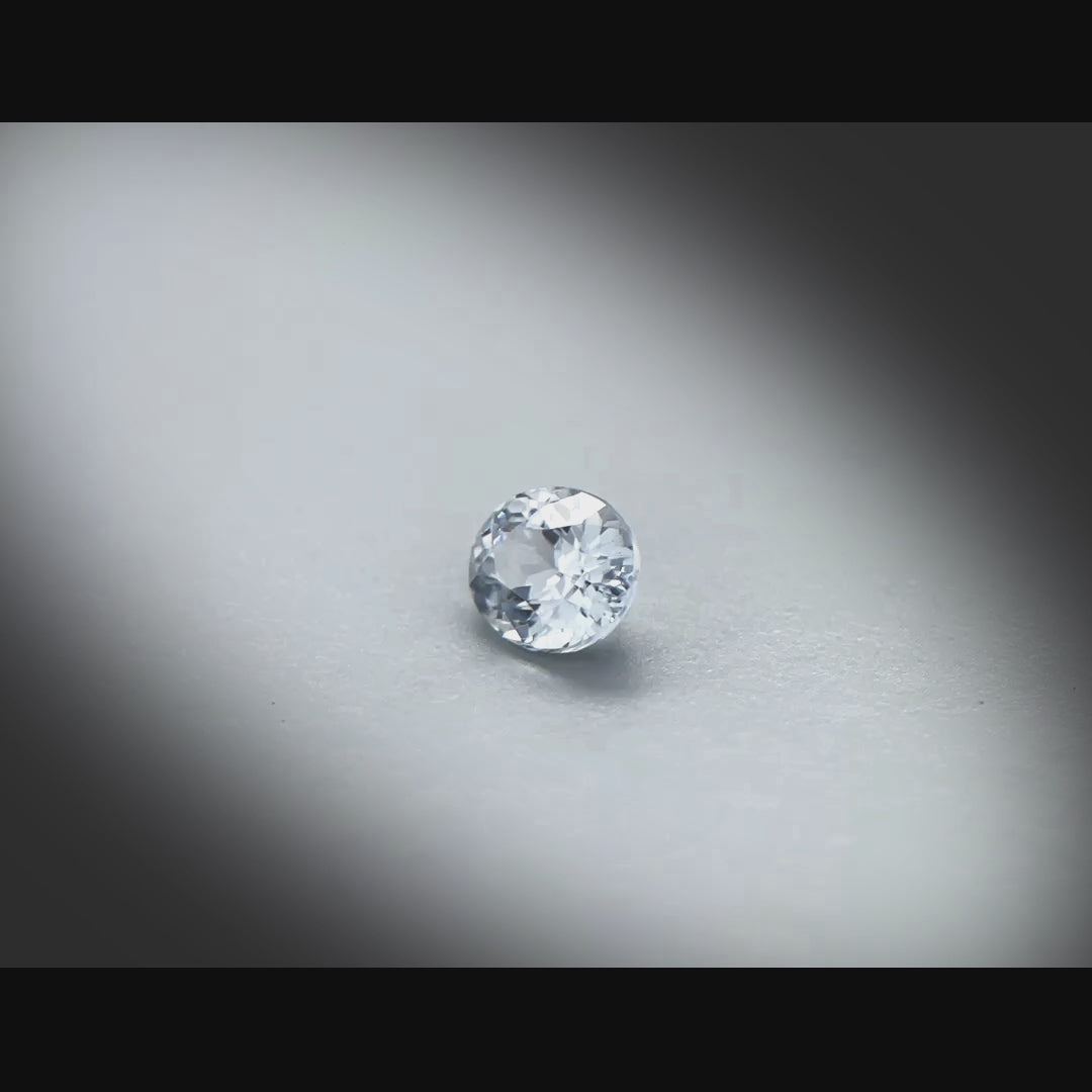 Vidéo d’un spinelle naturel ovale de 0.66ct, originaire du Sri Lanka, de couleur gris très léger, tournant à 360 degrés sur un fond gris clair