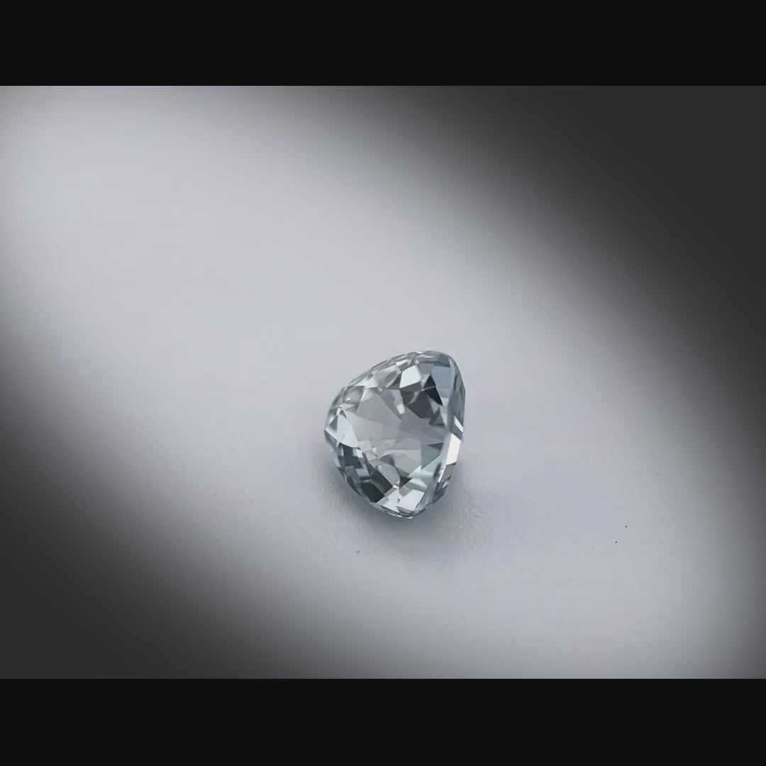 Vidéo d’un spinelle naturel gris-bleuté trillion de 1.13 ct, facetté et sans inclusion visible, originaire du Myanmar, tournant à 360 degrés sur fond gris clair