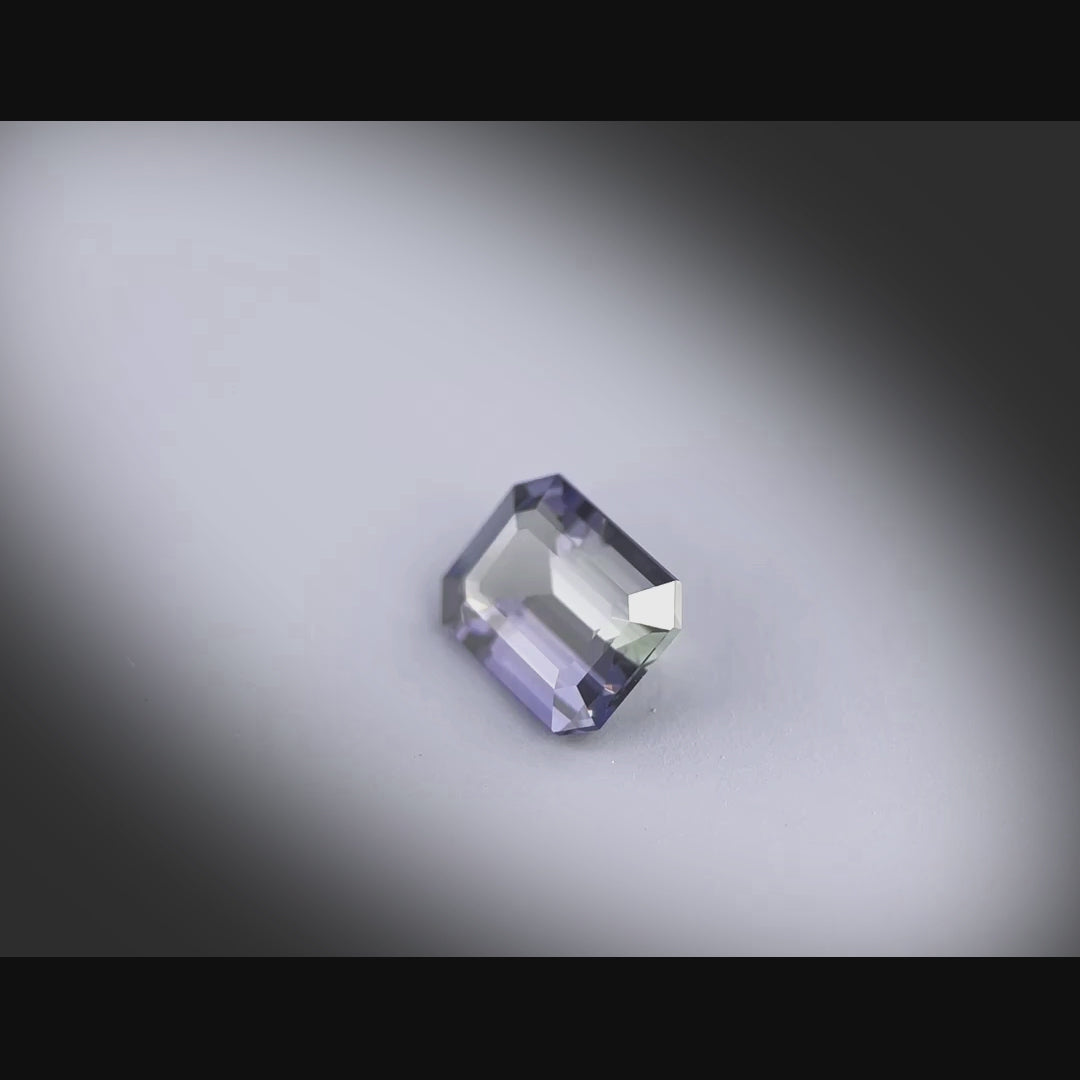 Vidéo d’un saphir naturel multicolore rectangulaire à pans coupés de 1.75 ct, facetté et sans inclusion visible, originaire de Madagascar, tournant à 360 degrés sur fond gris clair