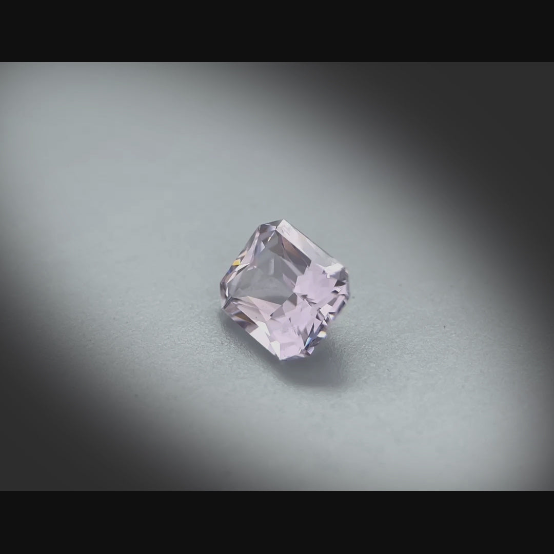 Vidéo d’un spinelle naturel violet-gris rectangulaire à pans coupés de 1.72 ct, facetté, originaire de Madagascar, tournant à 360 degrés sur fond gris clair.