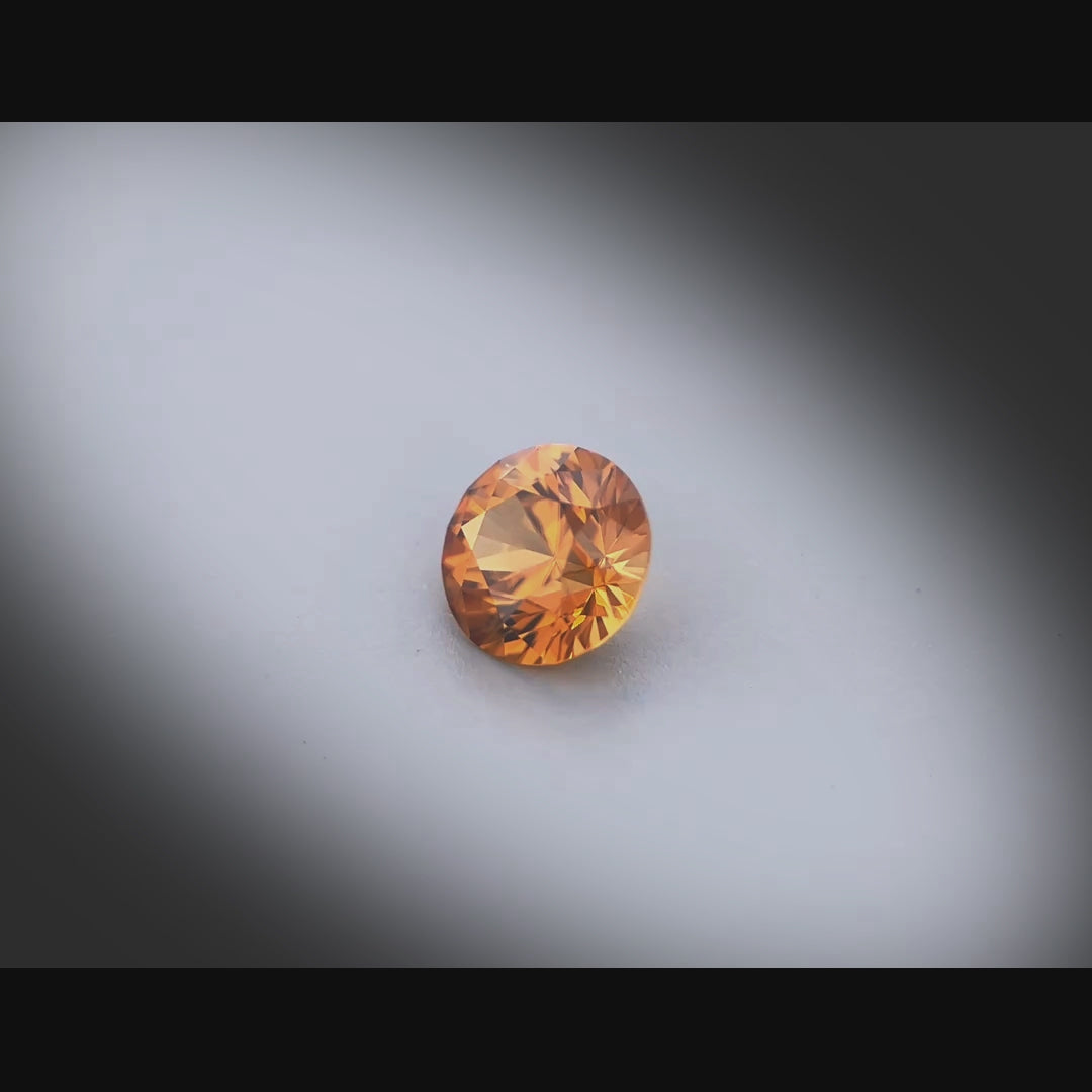 Vidéo d’un zircon orange rond facetté 1,75ct, couleur orange-brun soutenu, pureté élevée, Tanzanie