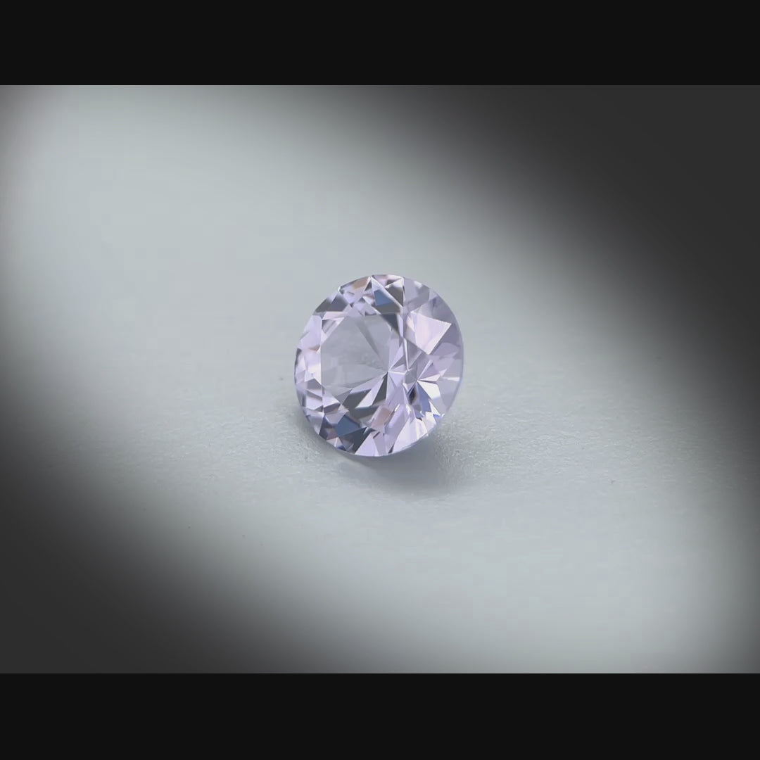 Vidéo d’un spinelle naturel rond de 1.66 ct, originaire de Tanzanie, de couleur gris-violet très léger, tournant à 360 degrés sur un fond gris clair