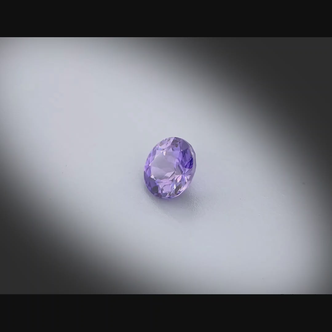 Vidéo d’un saphir violet naturel rond de 0.62 ct, non chauffé de couleur violet profond, originaire de Madagascar, tournant à 360 degrés sur fond gris clair