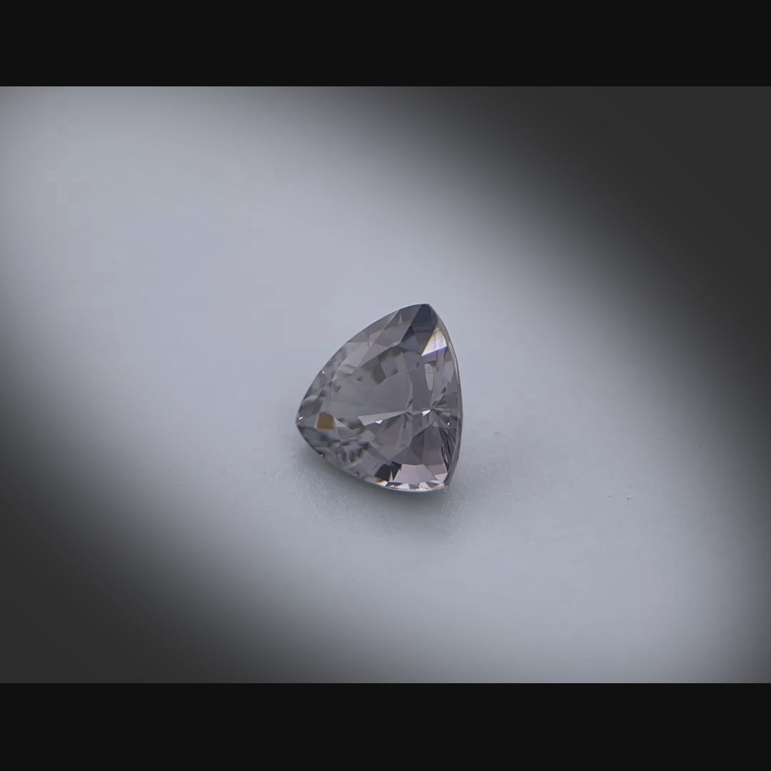 Vidéo d’un spinelle gris naturel trillion facetté de 1.05 ct, originaire du Myanmar, de couleur gris soutenu, tournant à 360 degrés sur fond gris clair