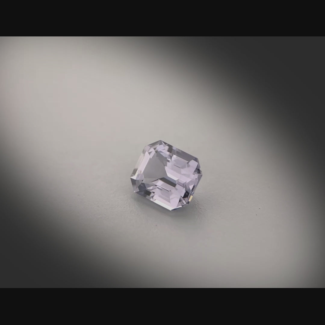 Vidéo d’un spinelle naturel gris-violet rectangulaire à pans coupés de 1.23 ct, facetté, originaire de Tanzanie, tournant à 360 degrés sur fond gris clair.