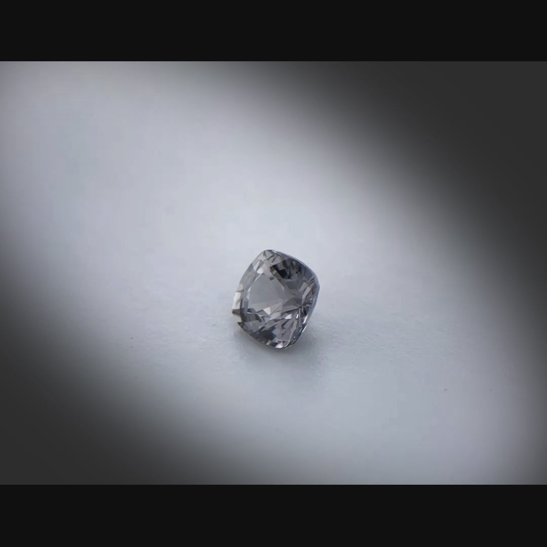 Vidéo d’un spinelle gris naturel coussin carré facetté de 1.04 ct, originaire du Myanmar, de couleur gris soutenu, tournant à 360 degrés sur fond gris clair