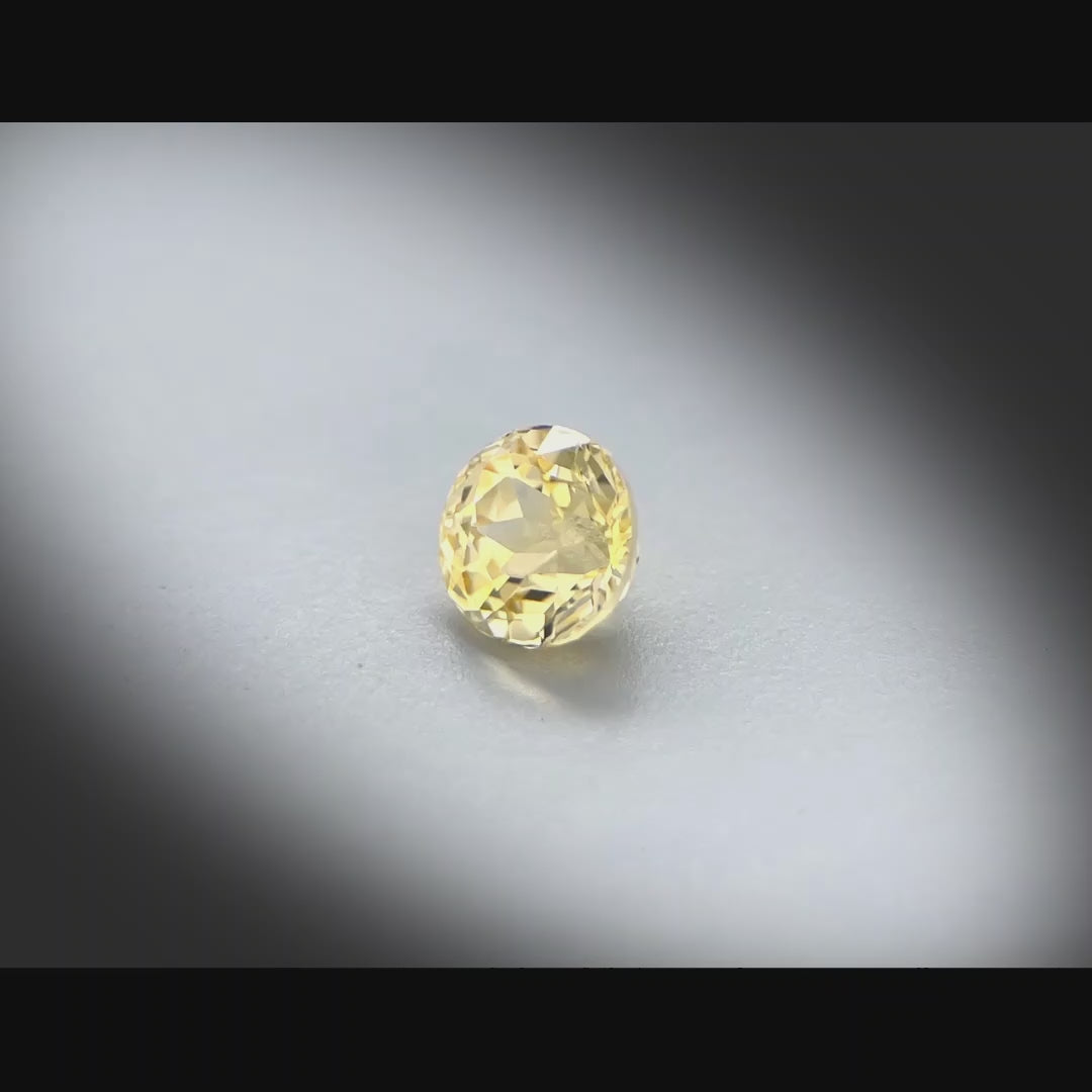 Vidéo d’un saphir jaune naturel non chauffé rond de 1.02 ct, de couleur jaune-doré soutenue, originaire de Madagascar, tournant à 360 degrés sur fond gris clair