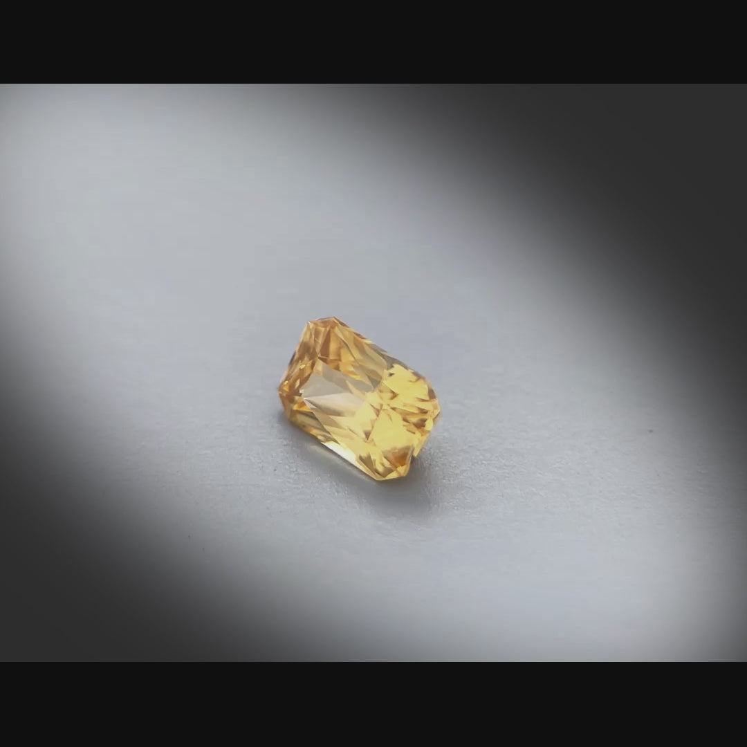 Vidéo d’un zircon naturel jaune rectangulaire à pans coupés de 1.53 ct, facetté, chauffé, originaire du Sri Lanka, tournant à 360 degrés sur fond gris clair