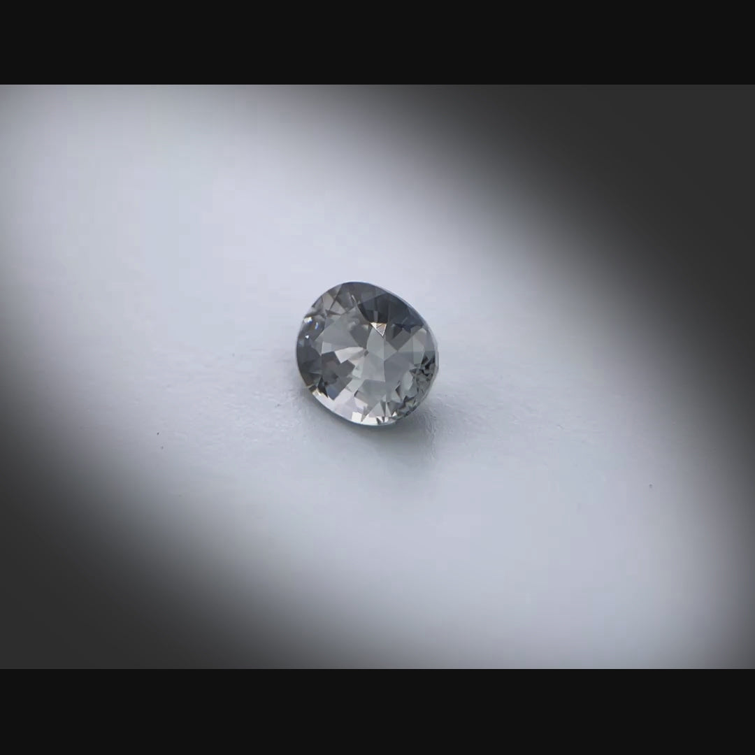 Vidéo d’un spinelle naturel ovale de 1.08 ct, originaire du Myanmar, de couleur grise soutenue, tournant à 360 degrés sur un fond gris clair