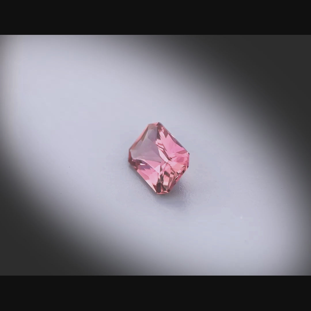 Vidéo d’un saphir naturel rose-brun rectangulaire à pans coupés de 1.22 ct, facetté, gemme rare originaire de Madagascar, tournant à 360 degrés sur fond gris clair