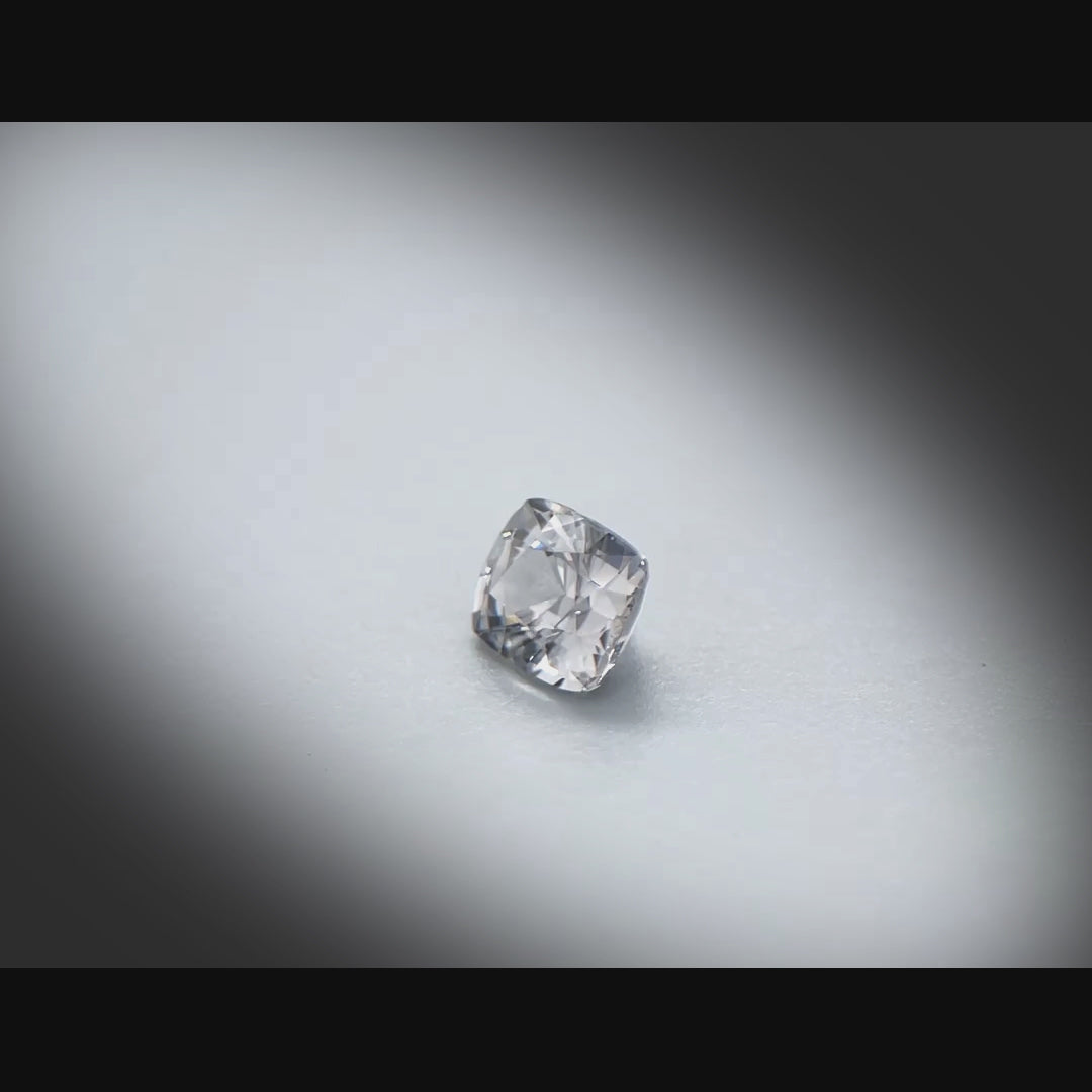 Vidéo d’un spinelle gris naturel coussin facetté de 0.85 ct, originaire du Myanmar, de couleur gris prononcé, tournant à 360 degrés sur fond gris clair