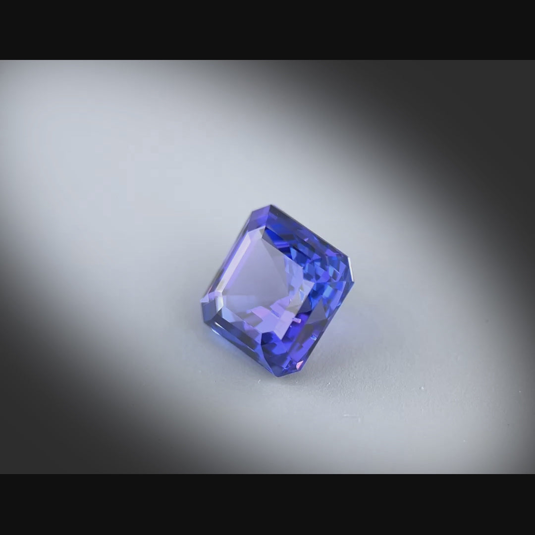 Vidéo d’une tanzanite naturelle de 2.71 ct, taille carrée à pans coupés, couleur bleu-violet intense, tournée à 360° sur fond gris clair
