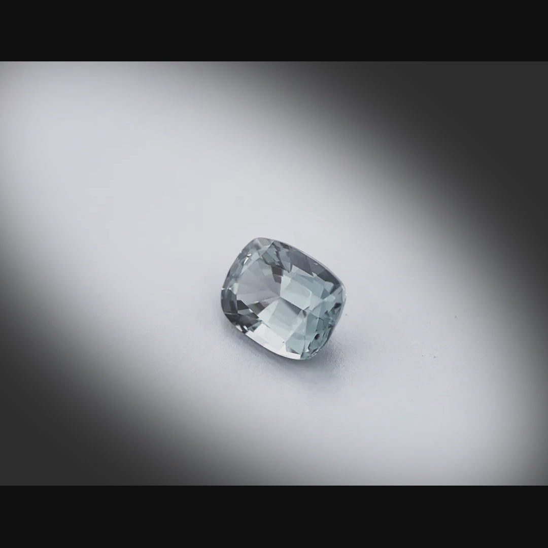 Vidéo d’un spinelle naturel coussin facetté de 1.20 ct, originaire du Myanmar, de couleur gris-bleuté soutenu, tournant à 360 degrés sur fond gris clair