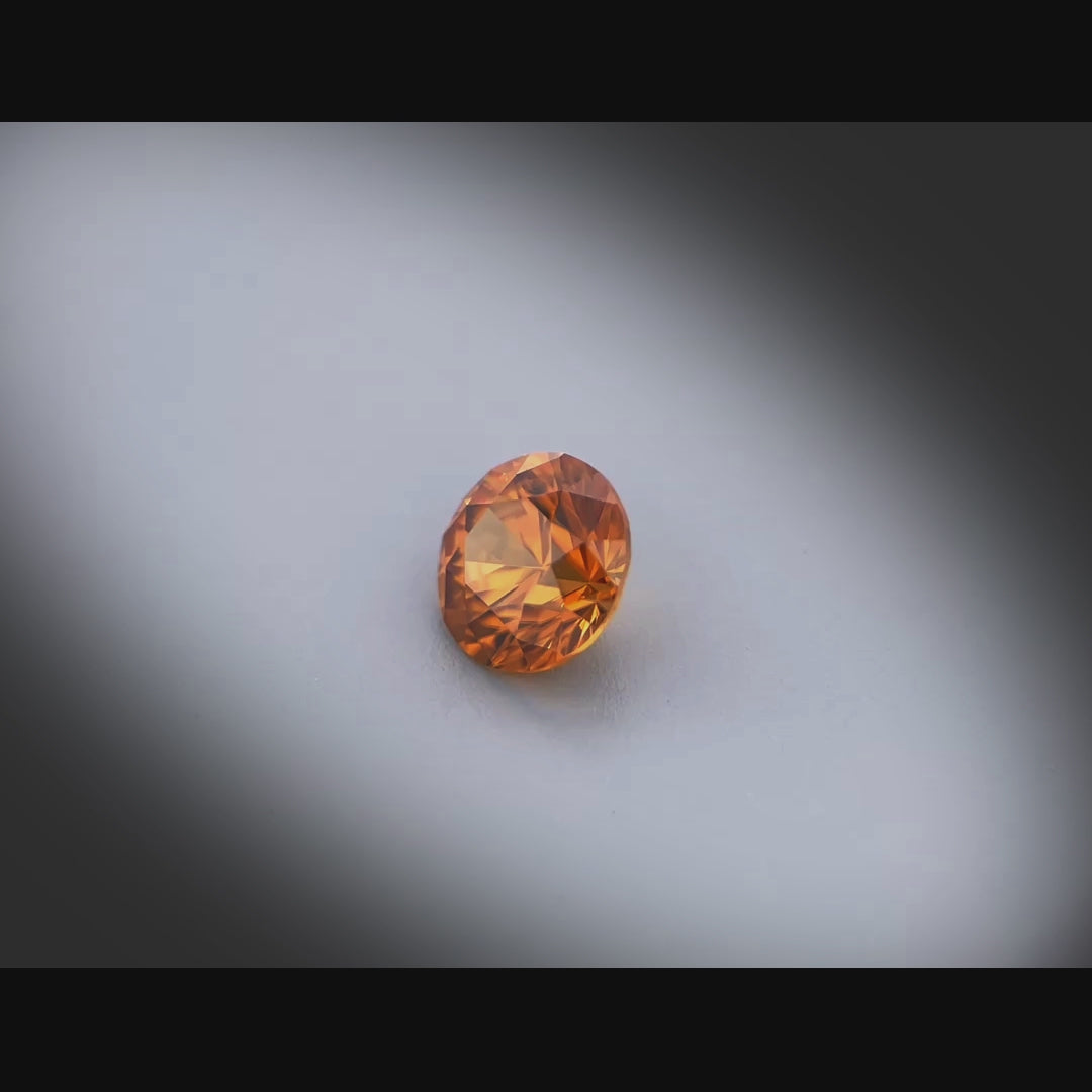 Vidéo d’un zircon orange rond facetté 1,84ct, teinte orange-brun soutenu, pureté sans inclusion, origine Tanzanie