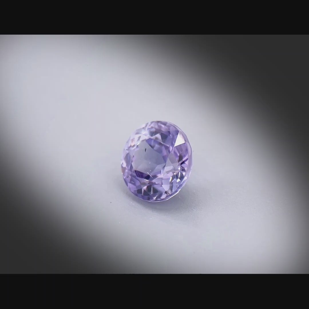 Vidéo d’un saphir bicolore naturel non chauffé rond de 1.60 ct, aux couleurs soutenues, originaire de Madagascar, tournant à 360 degrés sur fond gris clair