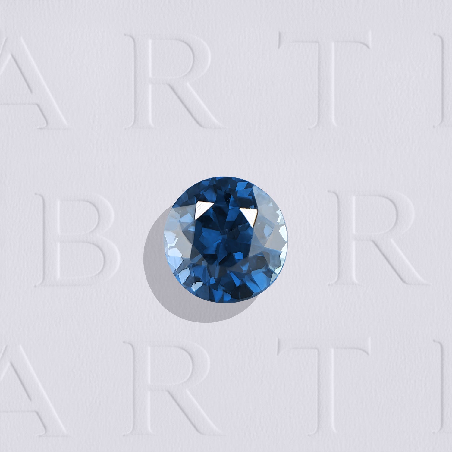 Saphir bleu naturel rond facetté de 0.46 carat, originaire de Madagascar, de couleur bleu profond aux nuances bleu jean, légèrement inclus et non traité.