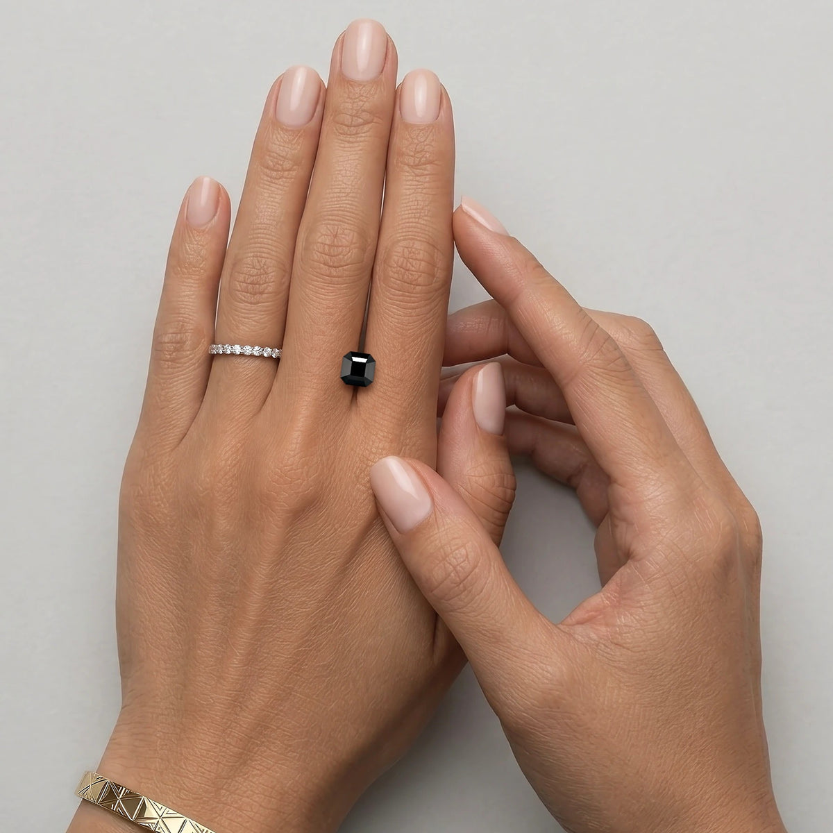 Spinelle noir non serti de 1,59 carat mesurant 6,5 mm de côté, présenté sur une main à taille réelle
