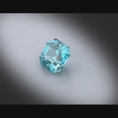 Vidéo d’un zircon bleu cyan naturel de 2.99 ct, taillé en carré à pans coupés, tournant à 360° sur fond gris clair