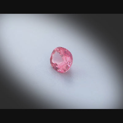 Vidéo d’un spinelle naturel rose-orangé ovale de 0.75 ct, facetté et sans inclusion visible, originaire du Vietnam, tournant à 360 degrés sur fond gris clair.