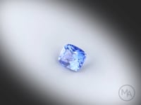 Vidéo d’un saphir bleu coussin rectangle facetté de 1.18 ct, originaire du Sri Lanka, de couleur bleu soutenu, chauffe traditionnelle, gemme en rotation sur un fond gris clair.