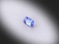 Vidéo d’un saphir bleu naturel rectangle à pans coupés facetté de 0.56 ct, originaire du Sri Lanka, de couleur bleu prononcé, rotation sur un fond gris clair.